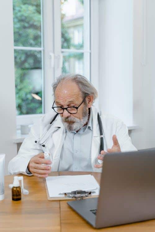 Doctor consulting a patient online with medications on the desk, illustrating telehealth prescription services.