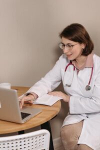 Doctor using a laptop to review patient information for an online doctor prescription