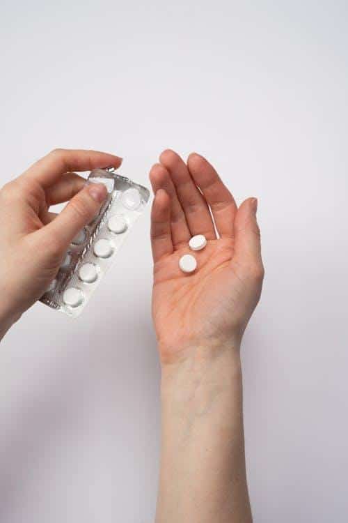 Person holding medication for online prescription refill and refilling med prescriptions at home