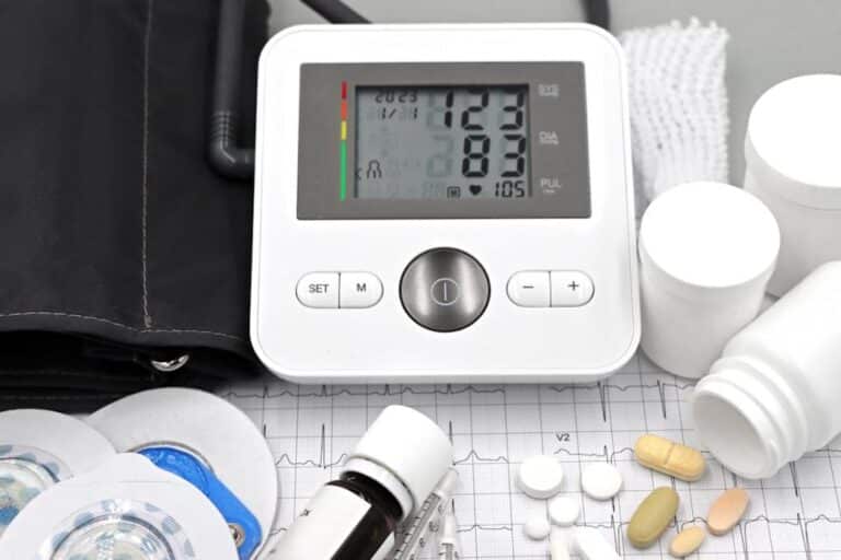Medical setup showing assorted pills placed beside an ECG printout, representing cardiovascular health monitoring and medication management.