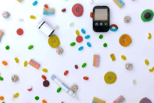 Glucose meter, syringe, and scattered candies
