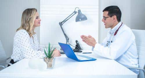Doctor discussing a medical diagnosis and treatment plan with a woman.