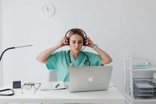 A doctor putting on headphones before starting a virtual telehealth consultation