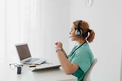 A doctor speaking with patient via video call during a telehealth consultation